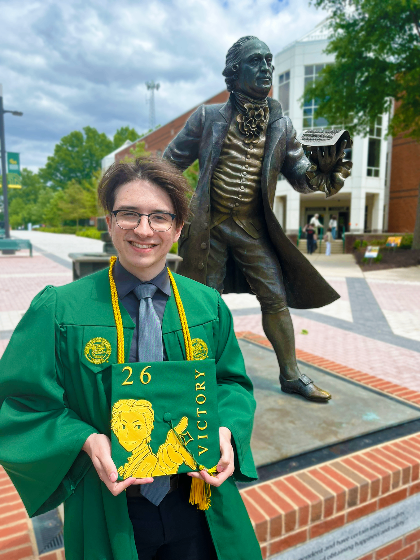 Alex at George Mason University graduation with decorated cap